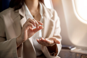 A woman taking airsickness pills to relieve herself from motion sickness before takeoff.