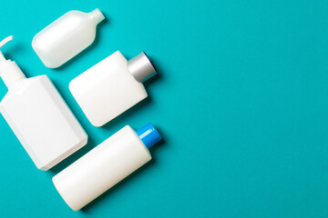 Set of White Cosmetic containers isolated on colored background, top view with copy space. Group of plastic bodycare bottle containers with empty space for you design