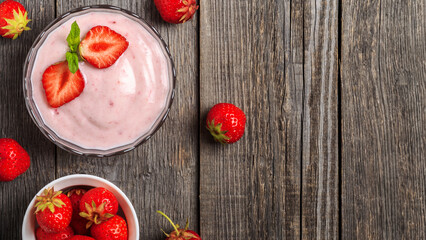 Homemade yogurt with fresh strawberry on a wooden background.