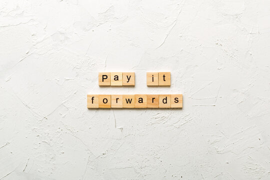 Pay It Forward word written on wood block. Pay It Forward text on cement table for your desing, concept