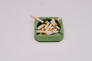 Cigarette butts and ashtrays used by people smoking were placed on white mats