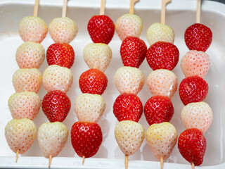 tanghulu, A food made by stringing fruits such as strawberries through bamboo and coating the...