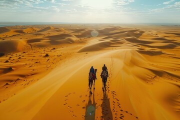 Fototapeta na wymiar Aerial view of Arabs riding camels walking across the vast desert