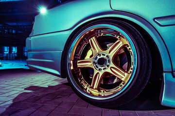 Close Up View of a Shiny Golden Alloy Wheel on a Blue Sports Car