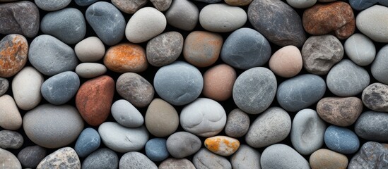 An assortment of rocks in a close-up view, including a small orange rock among the collection