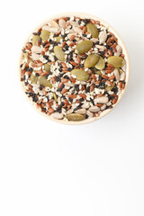 Fototapeta na wymiar Mixed seeds sunflower, black and white sesame, flax and pumpkin in bowl on white background. Top view. Space for a text