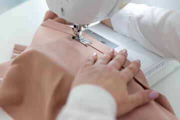pattern, scissors, tape measure, and a sewing machine. Workplace of seamstress. Dressmaker cuts...