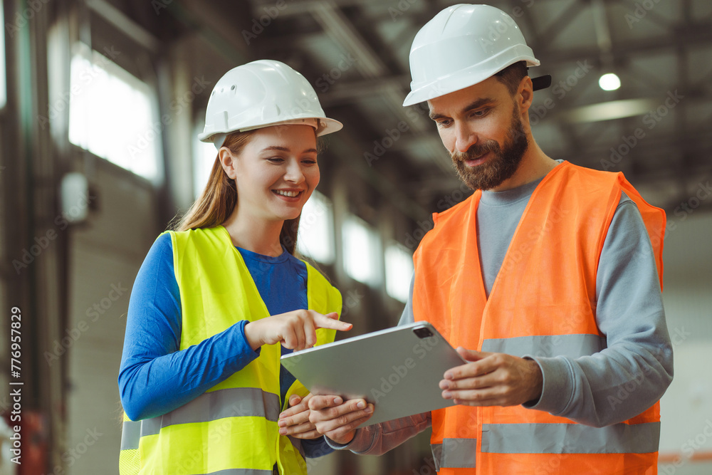 Wall mural engineers, factory foreman and female worker wearing protective white helmets, using digital tablet