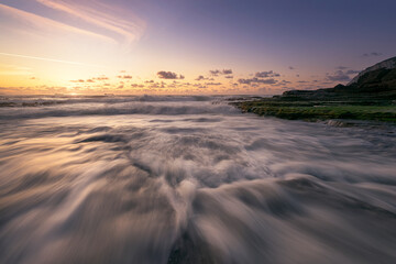 Closeup shot of the sea waves entering with intensity on Tunelboka beach in Getxo, Bizkaia at sunset - Powered by Adobe
