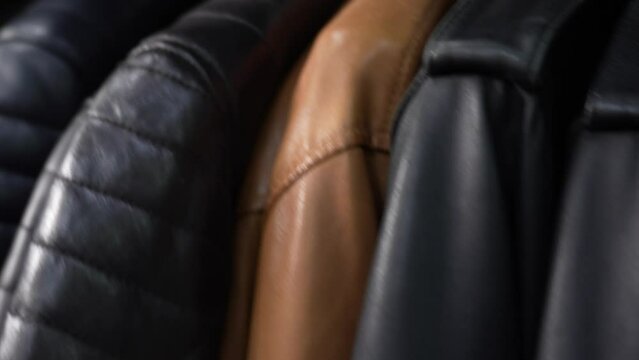 Male black and brown leather jackets on a hanger in a store