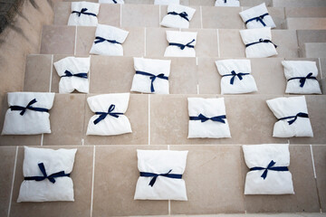 white cushions wrapped in a blue band arranged on marble stairs