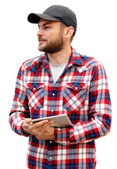 Isolated male farmer with digital tablet in hand, wearing casual red shirt and black cap, looking...