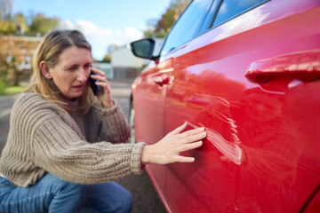 Unhappy Mature Female Driver With Damaged Car After Accident Calling Insurance Company On Mobile Phone - obrazy, fototapety, plakaty
