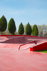 Empty public red skate park waiting for skaters. Skateboard in city. Skate and Bike Park. Extreme...