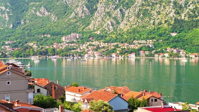 Kotor bay, Montenegro high angle aerial view on rooftop of residential buildings roofs in summer, ships and cruise boats on water by mountains 
