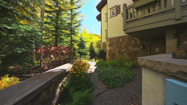 Vail Colorado pov point of view walking on backyard garden footpath of residential house building in wooden Swiss chalet architecture in autumn fall