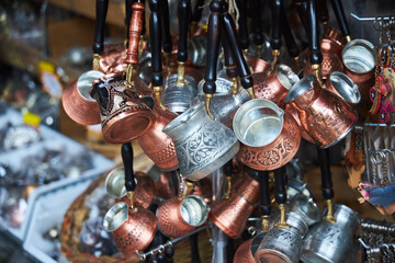 A large number of metal and copper utensils for brewing coffee. Souvenir sales