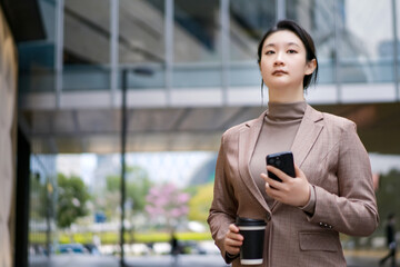 Confident Professional Woman Walking with Smartphone - 777007424