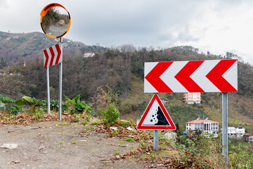 Road signs and convex mirror mounted on a roadside of a mountain road - 777011683