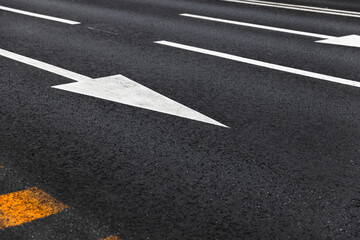 White arrows and lines, road marking on dark highway asphalt - 777011839