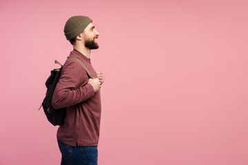 Fototapeta premium Side view of the smiling student with backpack looking away isolated