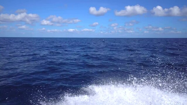 Moving fishing motor boat at the sea. Large fishing ship equipped with nets and a trawler sails through the azure water Sunset rays on water from luxury sail yacht during regatta in ocean
