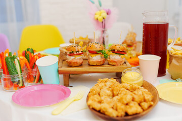 A set table with snacks. french fries, mini burgers and nuggets. 