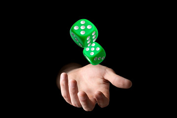 Man throwing green dice on black background, closeup