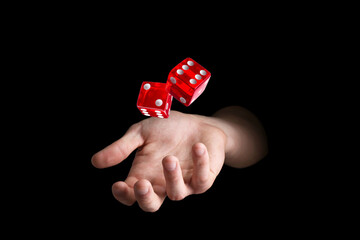 Man throwing red dice on black background, closeup