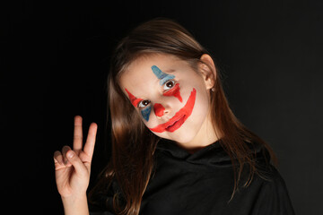 Halloween clown girl portrait on dark background , close-up