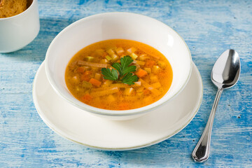 Top view of healthy vegetable soup on white porcelain plate