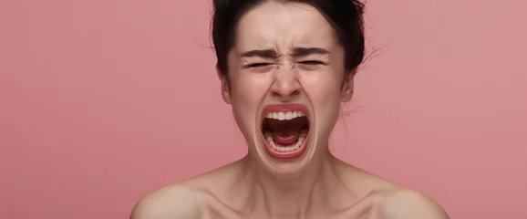 Fotobehang Studio portrait of woman screaming and yelling with hormonal PMS rage, pink background  © Elena