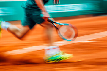 Motion blur of tennis player in action on clay court