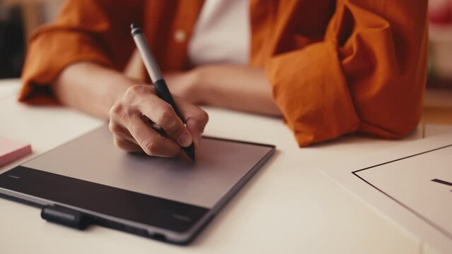 Woman designer working with a stylus pen, drawing design on a graphic tablet