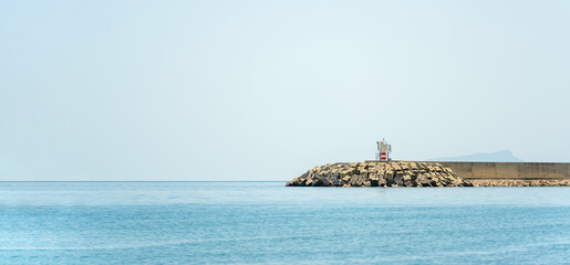 Breakwater and lighthouse at the entrance of the fishing harbor in Antalya Turkey - obrazy, fototapety, plakaty