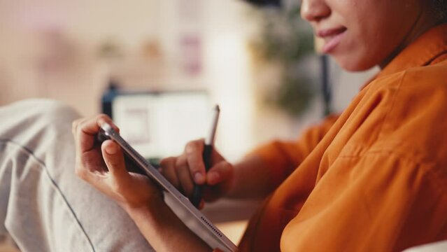 Smiling female designer drawing on graphic tablet in office, creative work