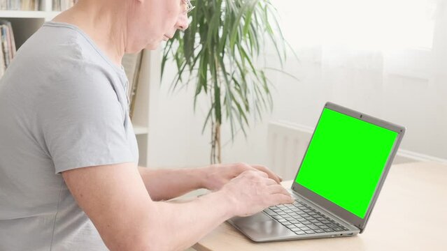 elderly man hesitantly uses laptop, green screen mockup, Senior Lifestyle, representing challenges and opportunities digital literacy for seniors, online communication
