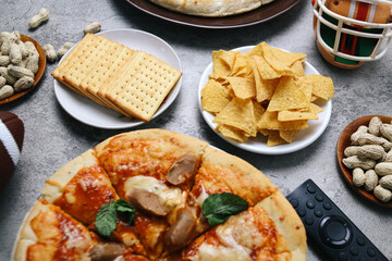 Assortments dish with pepperoni pizza, nachos or tortilla, cheese biscuits and sides on grey background. Super bowl concept