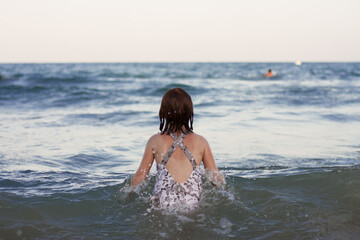 Fototapeta premium Girl from behind. Summer beach travel vacation concept. holiday with kids. Horizontal. Copy space. Mediterranean 