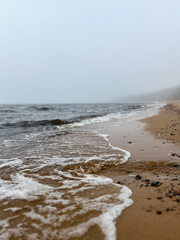 Waves on the foggy sea beach