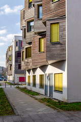 Berlin, Germany, March 7, 2024: street with housing block with white plaster facade and wooden bay...