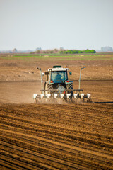 Farmer operating a tractor for sowing crops on fertile farmland, showcasing modern agriculture