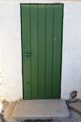 Green door on a white wall