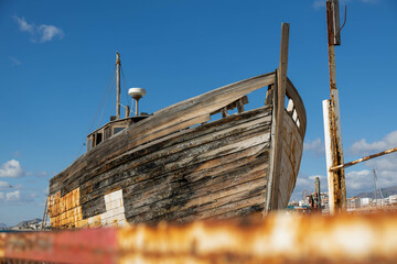 Abandoned wooden boat with blue sky