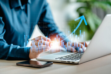 Businesswomen analyze on laptop the stock market with a digital virtual chart,  trend upside...