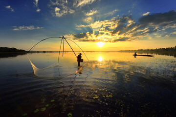 Silhouette of villager fisherman stand in the lakeand rising  a net . The background show other fisherman paddle a boat in the beautiful twilight. - obrazy, fototapety, plakaty