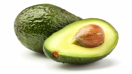 One whole and one halved avocado with a glossy, green skin and a large brown seed, isolated on a white background.