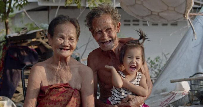 The smiling Asian husband and wife who are the poor elderly people in the ragpicker village who collect recycle garbage to sell for a living. They have to take care of their grandchild.
