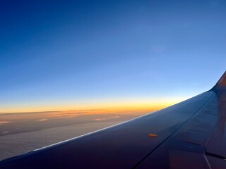 view from the airplane window, sunrise time, tender colors of the sky 