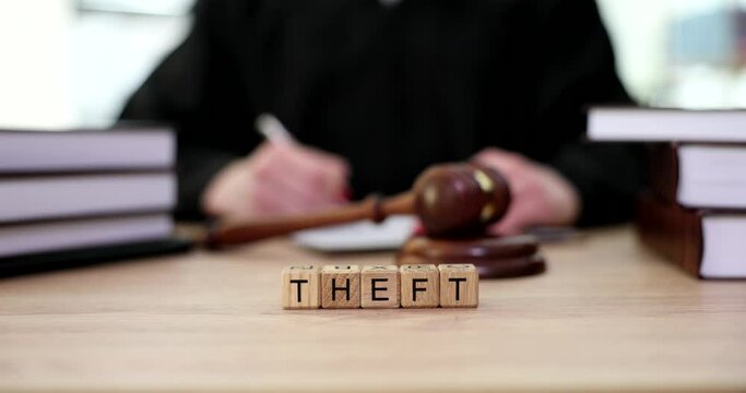 Word theft on wooden cubes on judge table near gavel closeup 4k movie slow motion. Criminal liability for theft concept